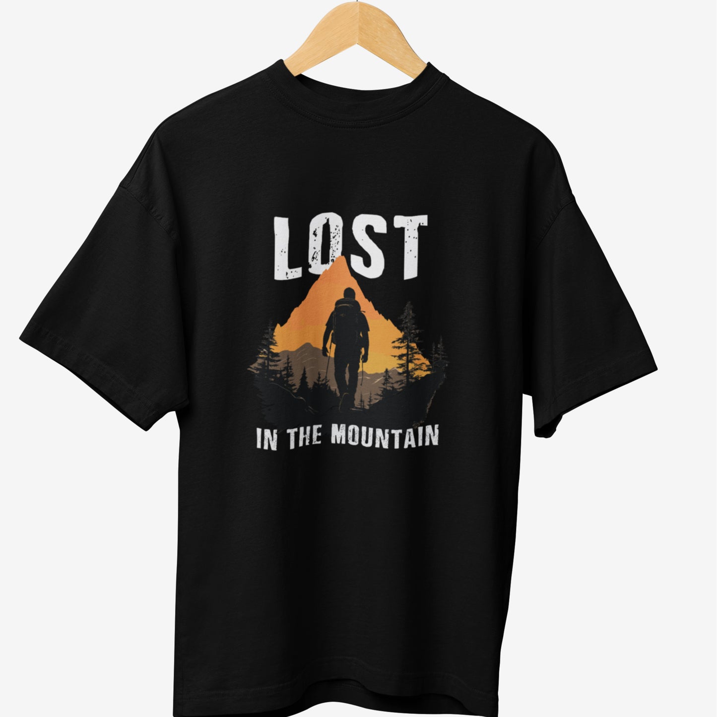 Black travel t-shirt featuring a rugged mountain adventure design with the phrase 'LOST IN THE MOUNTAIN,' depicting a lone hiker against a sunset-lit peak, perfect for outdoor explorers and travel enthusiasts.
