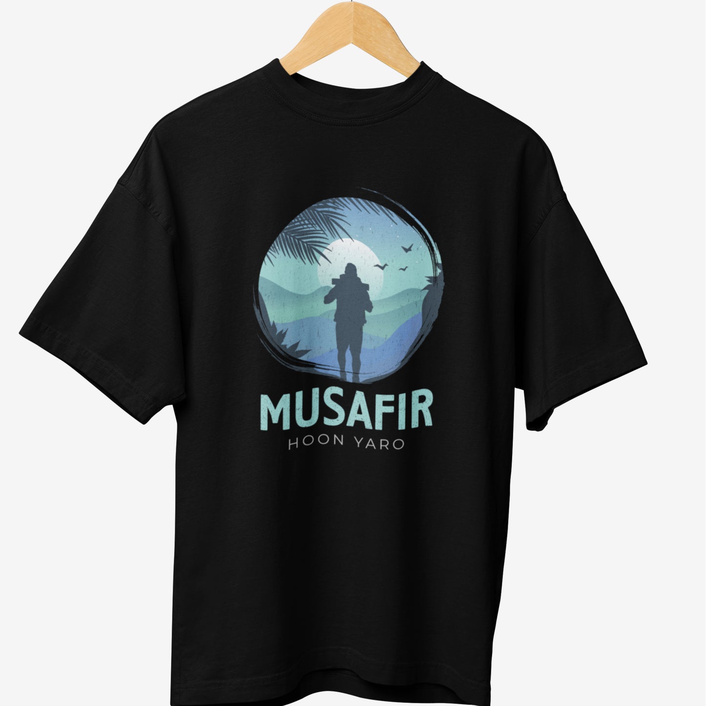Black travel t-shirt featuring a silhouette of a backpacker against a scenic blue mountain backdrop, with the phrase 'MUSAFIR HOON YARO,' perfect for wanderlust-driven explorers.