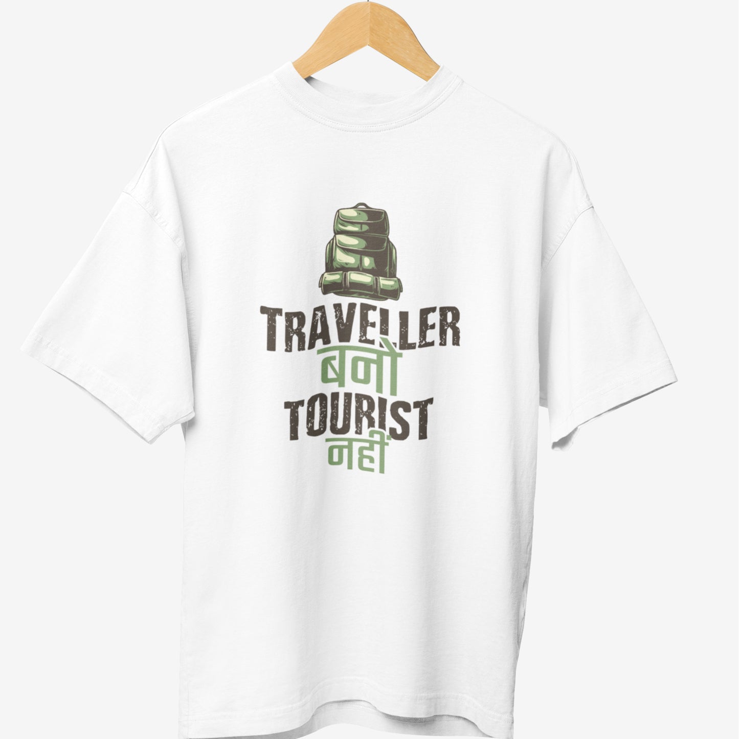 White travel t-shirt featuring a green backpack illustration with the Hindi and English phrase 'Traveller Bano, Tourist Nahi,' promoting adventure and exploration.