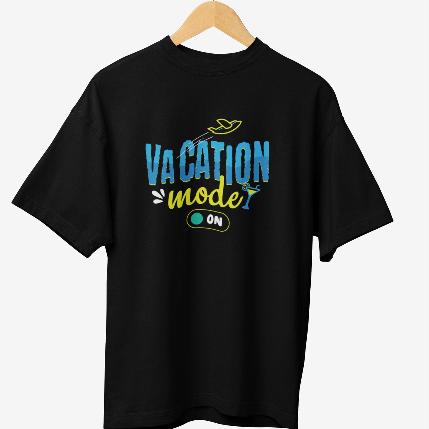 Black travel t-shirt featuring the phrase 'VACATION mode ON' in blue and yellow typography, with an airplane, a cocktail glass, and a switch icon representing relaxation and travel vibes.