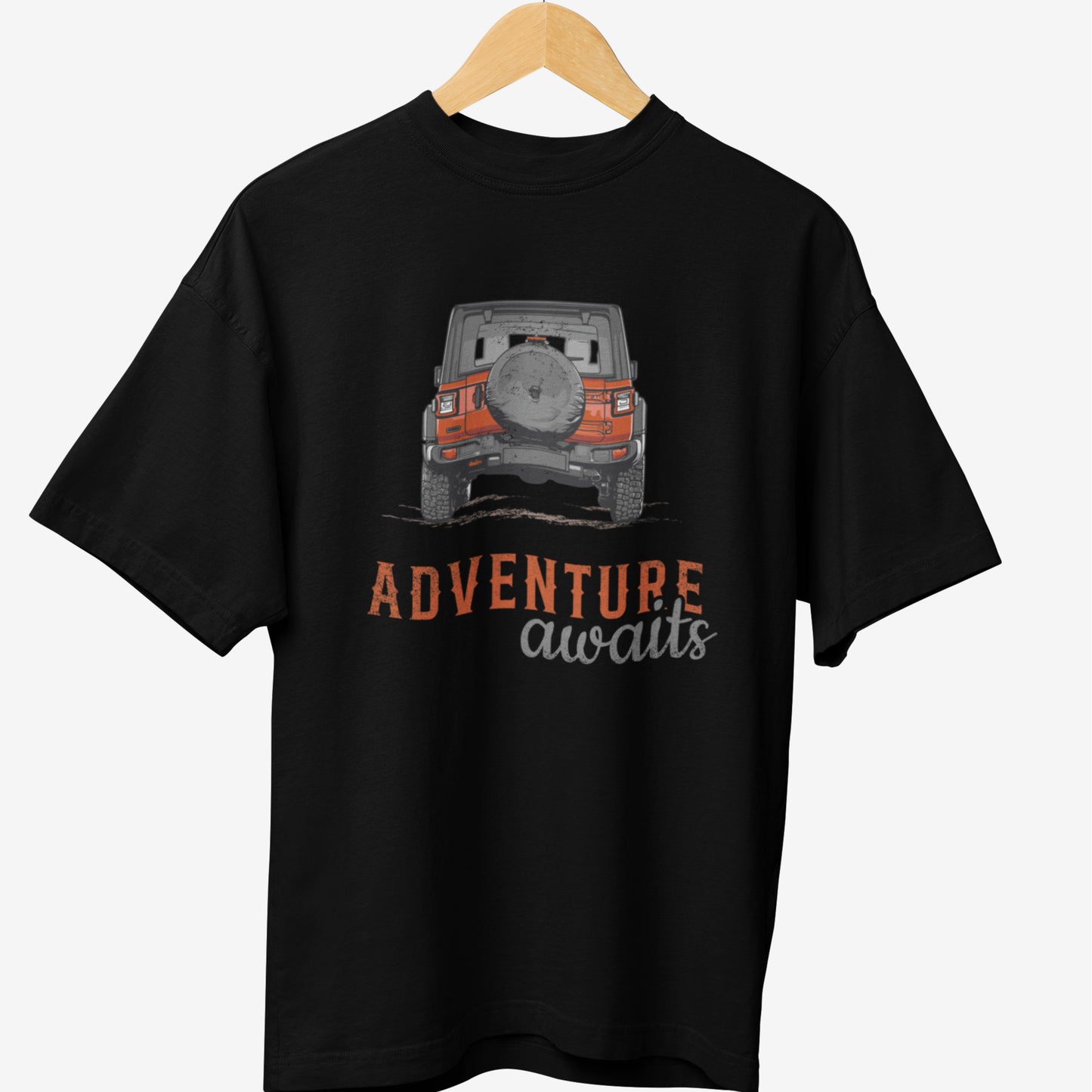 Black travel t-shirt featuring a graphic design of an off-road Jeep in orange and gray, with the text 'ADVENTURE awaits' in bold, distressed typography.